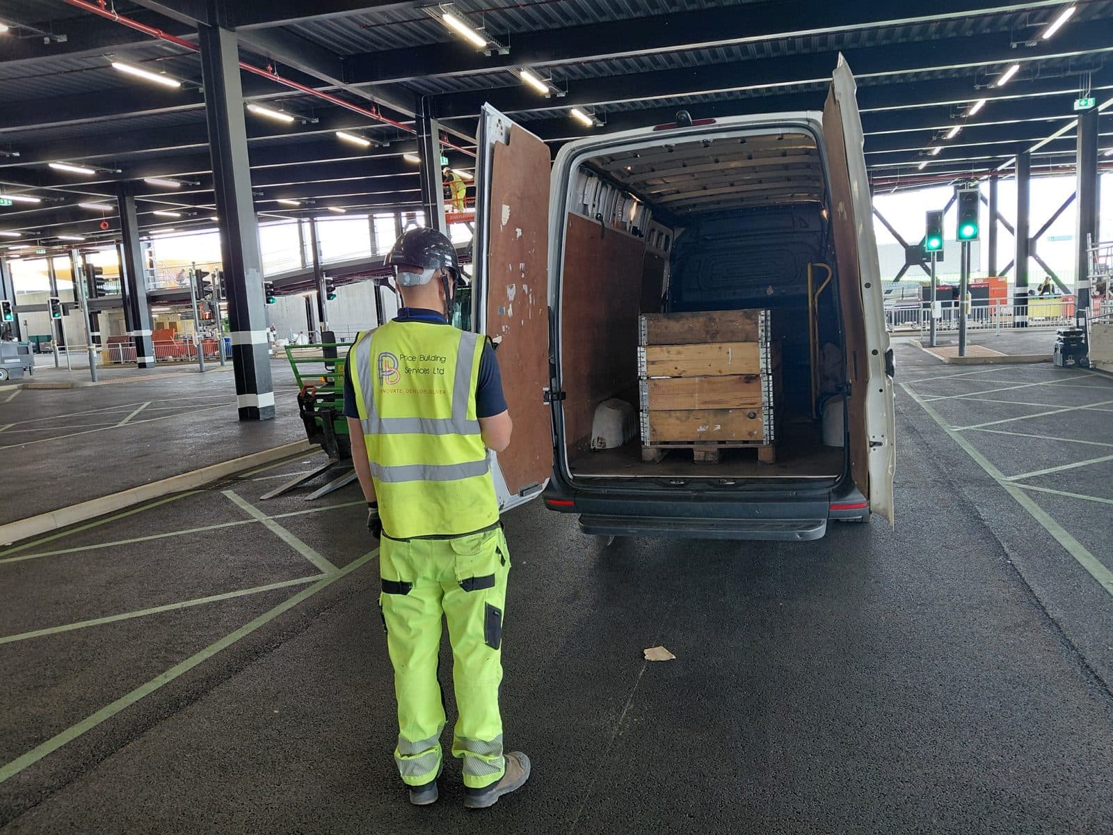 Birdview van delivering a crated pallet to a construction site