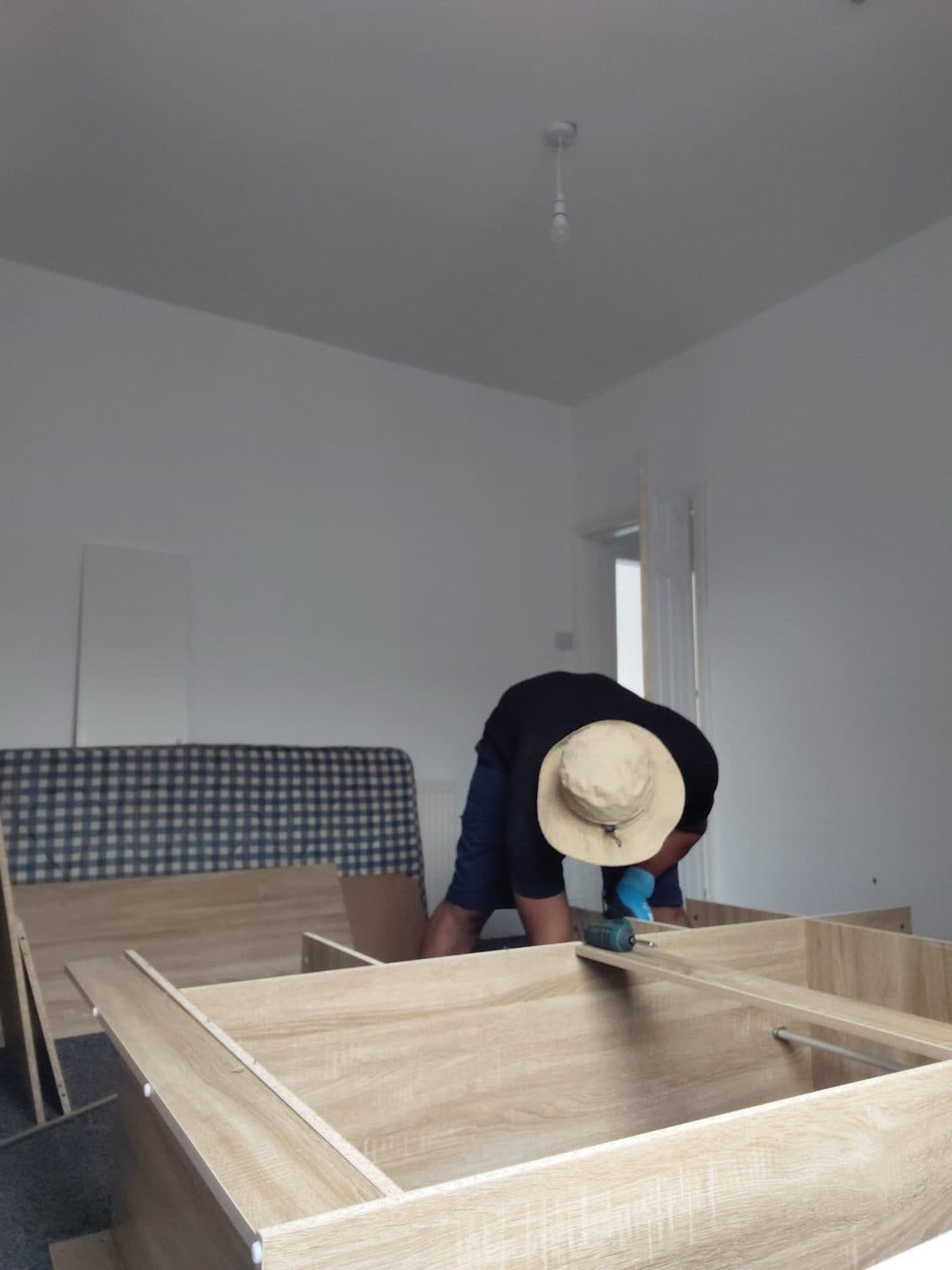 Team member assembling a wardrobe in a newly moved-into bedroom