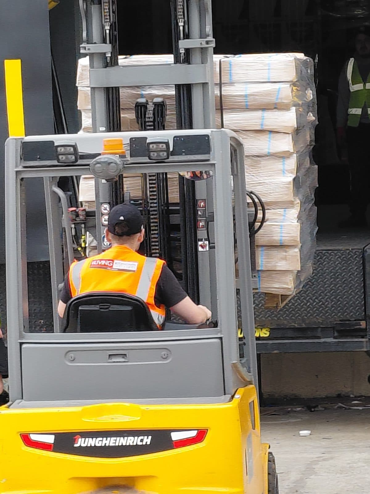 Wrapped pallet being loaded by forklift at a loading bay